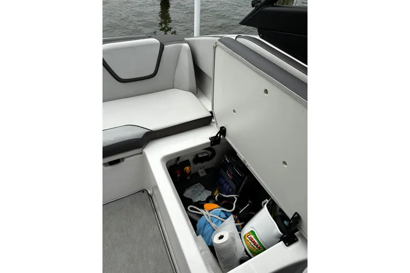 Slide: The Image of 2023 Yamaha AR250 boat storage compartment with cleaning supplies and accessories. - 21