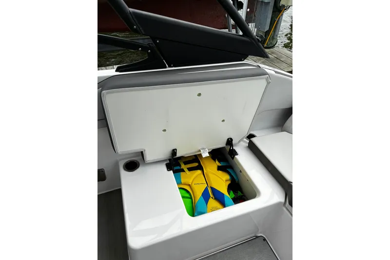 Slide: The Image of 2023 Yamaha Boats AR250 storage compartment with colorful life jackets inside. - 19