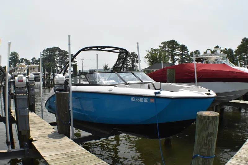 Slide: The Image of 2023 Yamaha Boats AR250 docked at a marina, featuring a sleek blue design. - 3