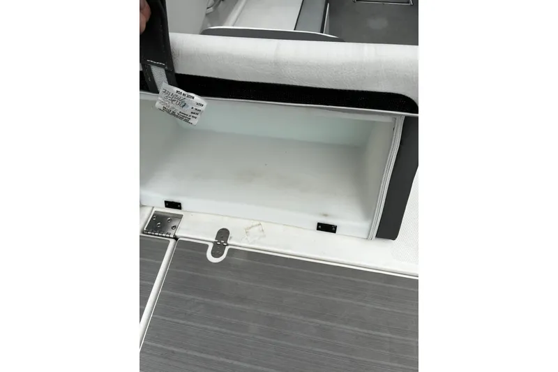 Slide: The Image of 2023 Yamaha Boats AR250 storage compartment with open lid, showcasing interior space. - 22