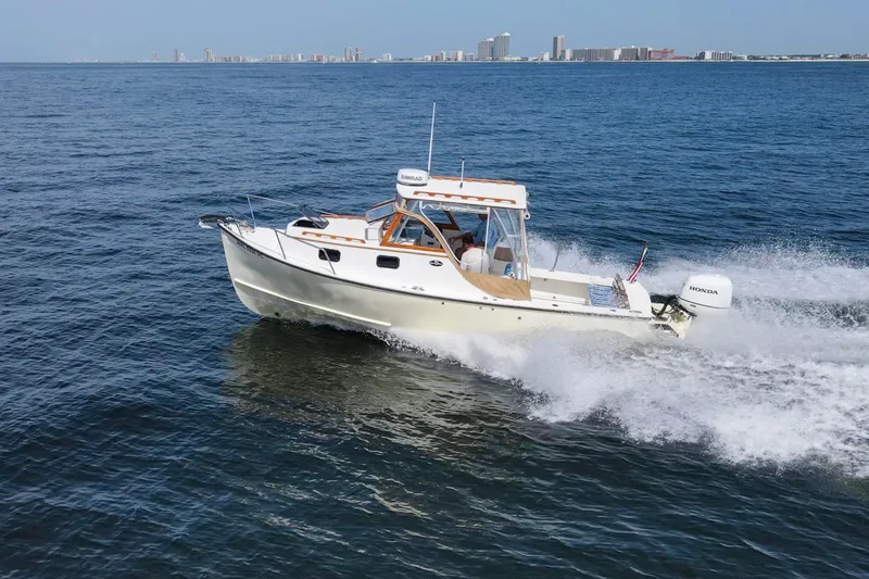 Slide: The Image of 2019 Seaway Seafarer 24 cruising on open water with city skyline in background. - 7