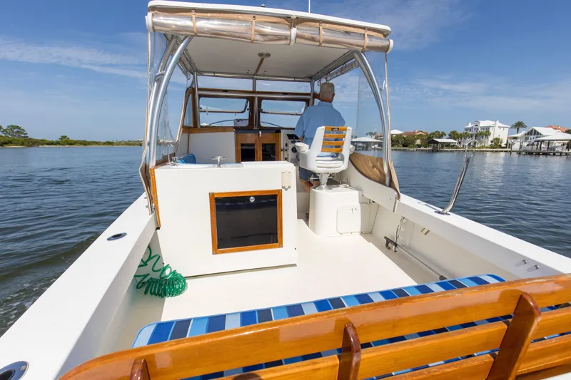 Slide: The Image of 2019 Seaway Seafarer 24 boat cruising on a calm waterway, featuring a spacious deck. - 18