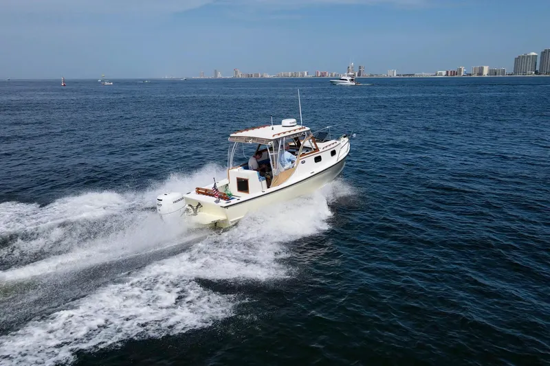 Slide: The Image of 2019 Seaway Seafarer 24 cruising on open water near city skyline. - 6