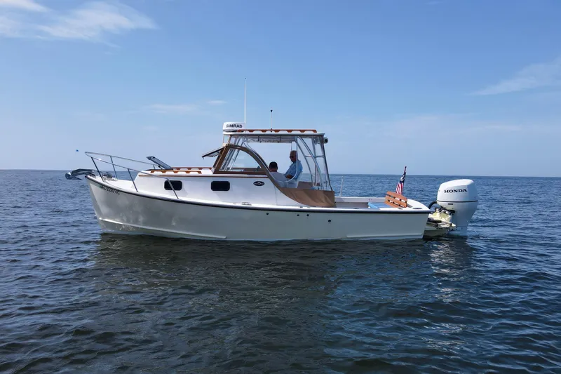 Slide: The Image of 2019 Seaway Seafarer 24 boat on calm ocean waters under clear blue sky. - 28