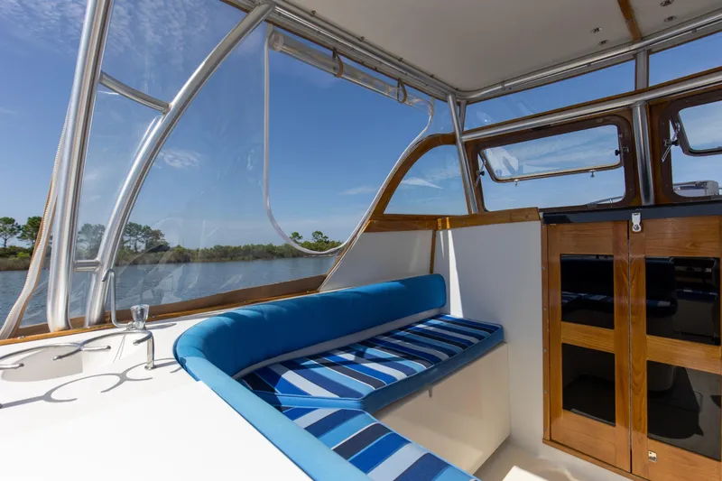 Slide: The Image of Interior of 2019 Seaway Seafarer 24 boat with blue-striped seating and wooden cabinetry. - 19