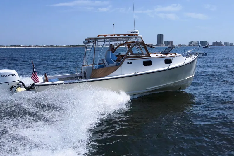 Slide: The Image of 2019 Seaway Seafarer 24 cruising on open water with city skyline in background. - 5