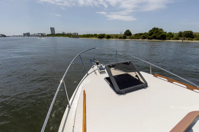 Slide: The Image of 2019 Seaway Seafarer 24 cruising on a scenic waterway with city skyline in background. - 21