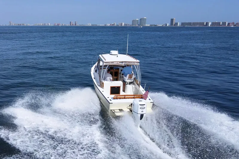 Slide: The Image of 2019 Seaway Seafarer 24 cruising on open water with city skyline in background. - 8