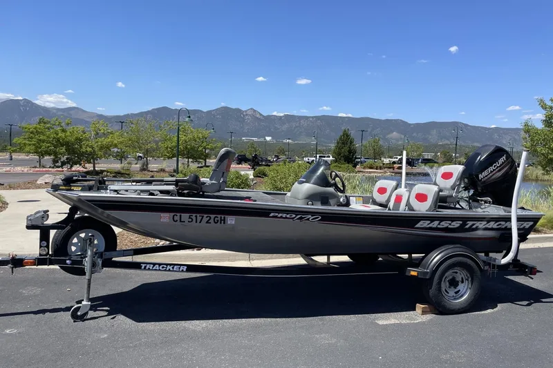 Slide: The Image of 2015 Tracker Pro 170 bass boat on trailer, parked with scenic mountain backdrop. - 3