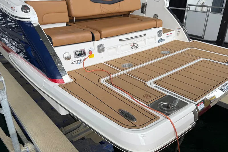 Slide: The Image of 2023 Chaparral 287 SSX boat with teak deck and tan seating at the stern. - 7