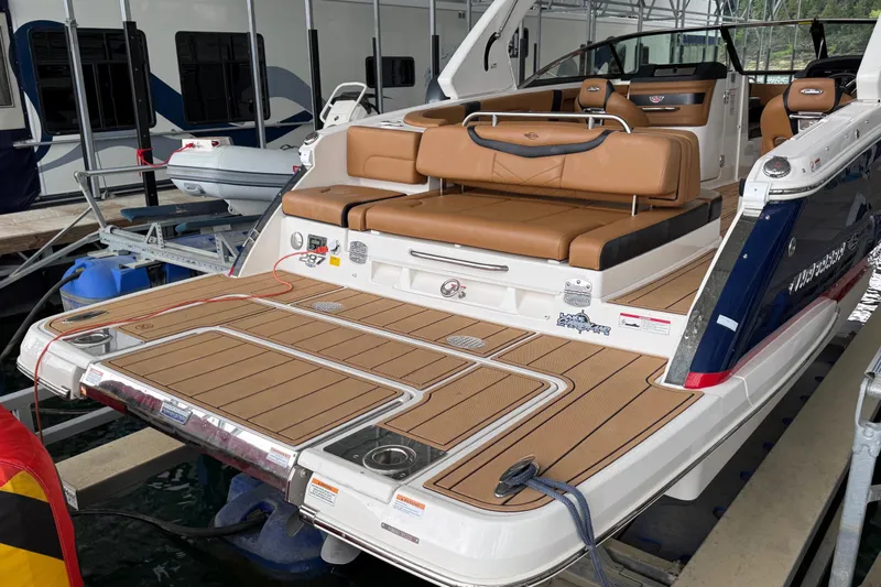 Slide: The Image of 2023 Chaparral 287 SSX boat with tan seating and spacious swim platform in marina. - 1