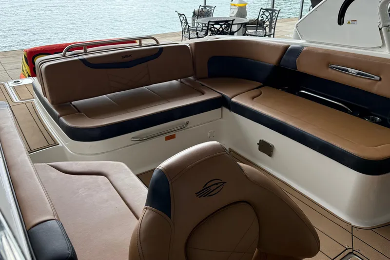 Slide: The Image of 2023 Chaparral 287 SSX boat interior with luxurious brown and black seating by the water. - 4