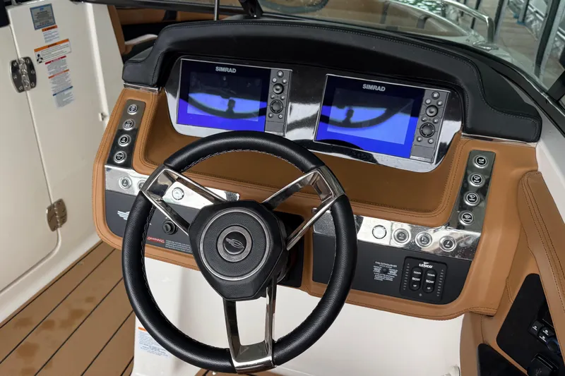 Slide: The Image of 2023 Chaparral 287 SSX boat dashboard with dual Simrad displays and leather-wrapped steering wheel. - 5