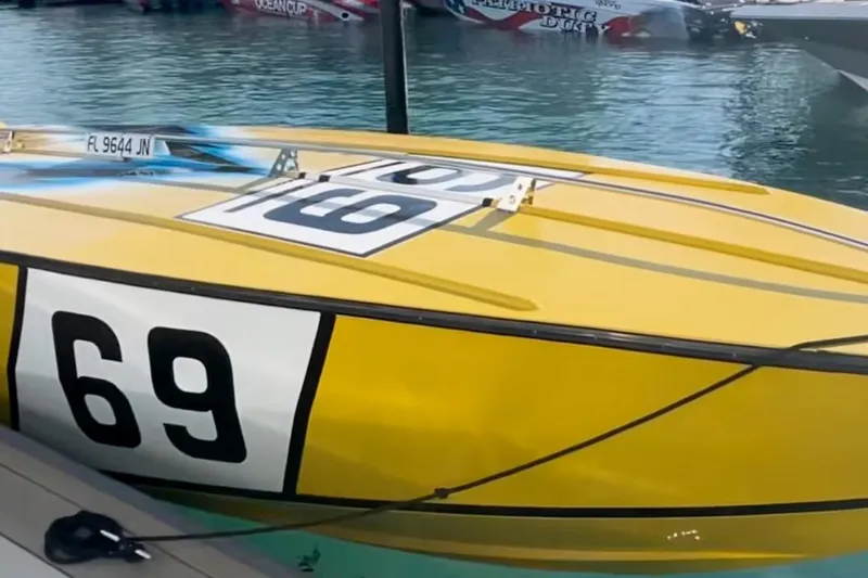 Slide: The Image of Yellow Apache 47 speedboat from 1987 with number 69, docked on water. - 6