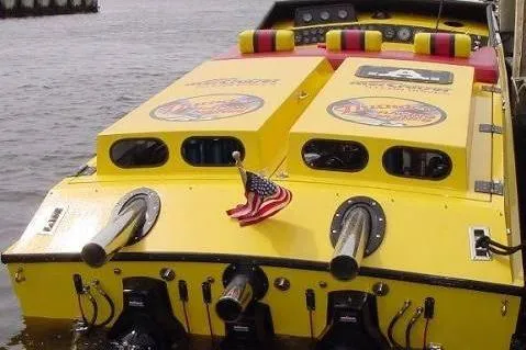 Slide: The Image of Yellow 1987 Apache 47 speedboat with dual exhausts and American flag on the water. - 9