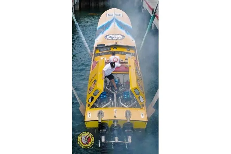 Slide: The Image of Yellow 1987 Apache 47 powerboat with visible engines, docked in water, viewed from above. - 10