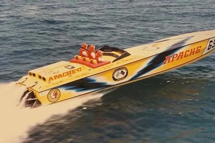 The Image of 1987 Apache 47 speedboat racing on open water, featuring vibrant graphics and sleek design. - 2