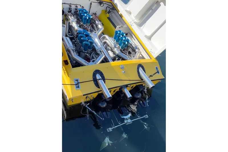 Slide: The Image of Yellow 1987 Apache 47 boat engine with dual exhausts and visible propellers in water. - 14