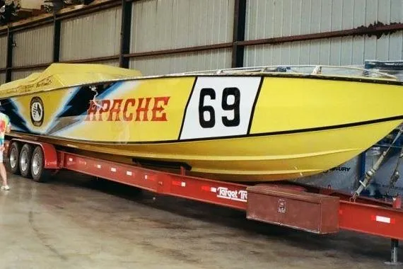 Slide: The Image of Yellow 1987 Apache 47 speedboat with number 69 on a trailer in a warehouse. - 17