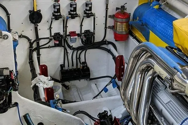 Slide: The Image of Engine room of a 1987 Apache 47 boat, featuring complex wiring and exhaust system. - 16