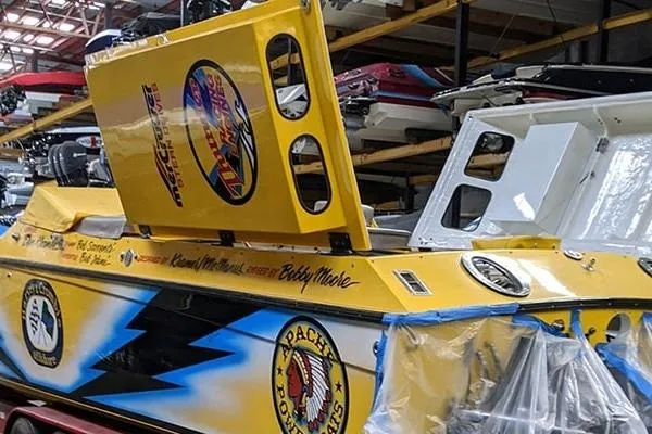 Slide: The Image of Yellow Apache 47 speedboat from 1987 with vibrant decals in a storage facility. - 15