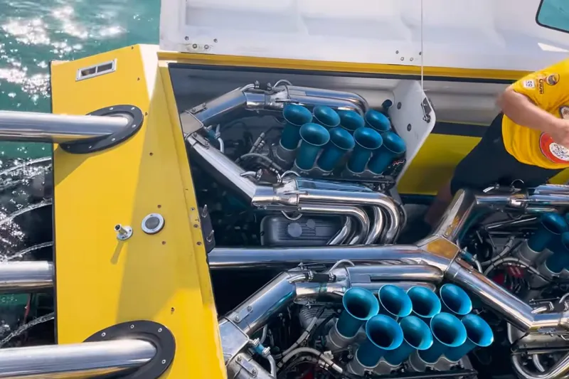 Slide: The Image of Yellow Apache 47 boat engine from 1987 with chrome exhausts and blue intake stacks. - 13