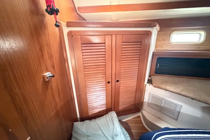 Slide: The Image of Interior cabin of a 1995 Catalina 400 sailboat with wooden closet and cozy bedding. - 36