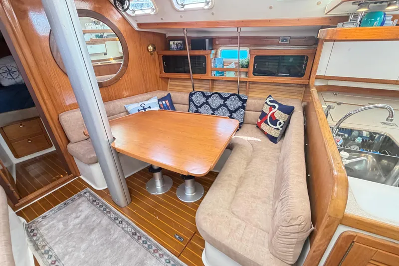 Slide: The Image of Cozy interior of a 1995 Catalina 400 sailboat with a dining area and nautical decor. - 27