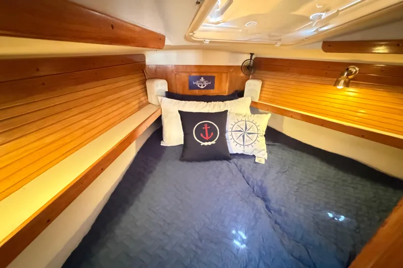Slide: The Image of Cozy cabin interior of a 1995 Catalina 400 sailboat with nautical-themed pillows. - 39