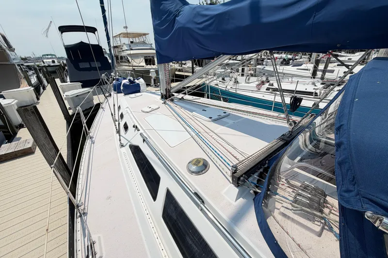 Slide: The Image of 1995 Catalina 400 sailboat docked at marina, featuring blue covers and rigging details. - 15
