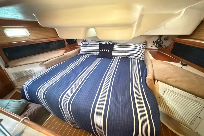 Slide: The Image of Cozy cabin interior of 1995 Catalina 400 sailboat with striped bedding and wooden accents. - 32