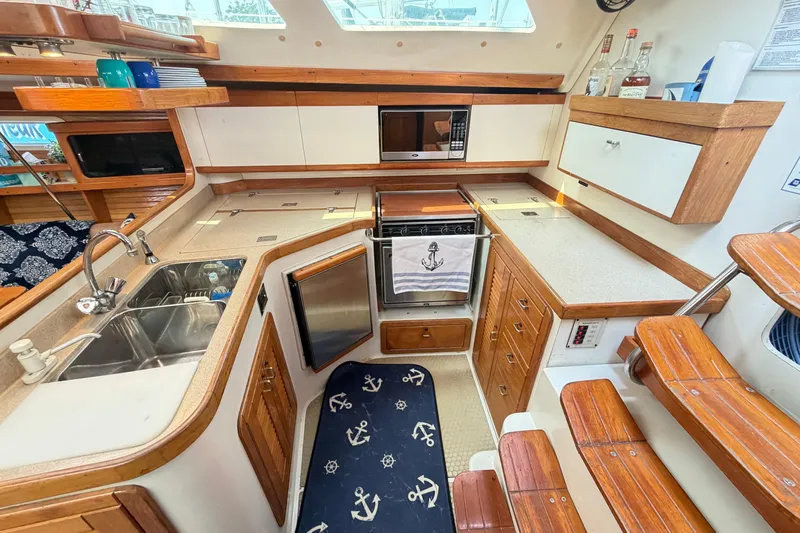 Slide: The Image of Cozy 1995 Catalina 400 yacht kitchen with wooden cabinetry and nautical decor. - 21