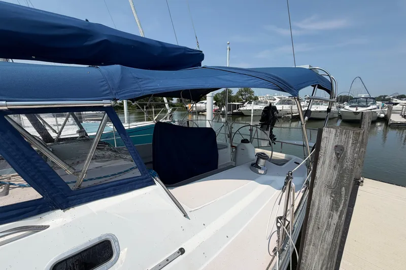 Slide: The Image of 1995 Catalina 400 sailboat docked at marina with blue canopy and clear skies. - 4