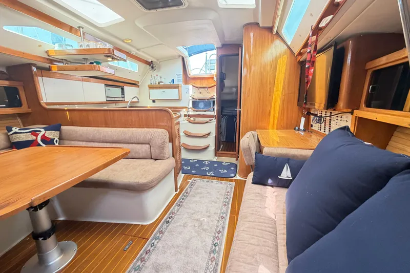 Slide: The Image of Interior of a 1995 Catalina 400 sailboat, featuring cozy seating and wooden finishes. - 30
