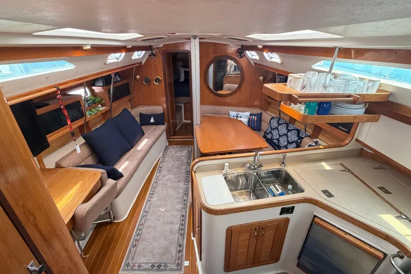 Slide: The Image of Interior of a 1995 Catalina 400 sailboat, featuring a cozy living area and kitchen. - 20