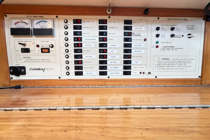 Slide: The Image of Electrical control panel of a 1995 Catalina 400 yacht, featuring switches and gauges. - 31