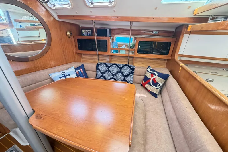 Slide: The Image of Cozy interior of a 1995 Catalina 400 sailboat with cushioned seating and decorative pillows. - 28