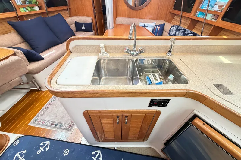 Slide: The Image of Interior of a 1995 Catalina 400 yacht featuring a kitchen sink and cozy seating area. - 22