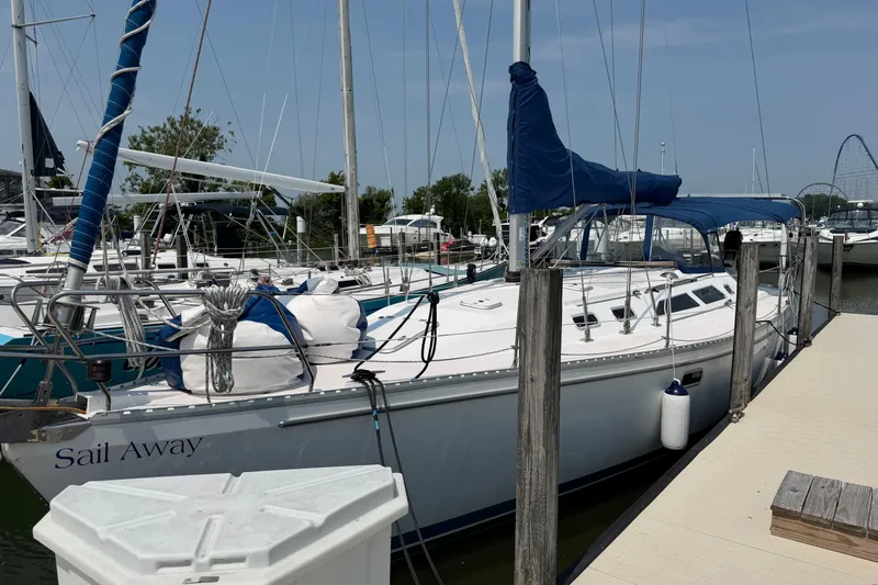 Slide: The Image of 1995 Catalina 400 sailboat docked at marina, named "Sail Away," with blue sail cover. - 1