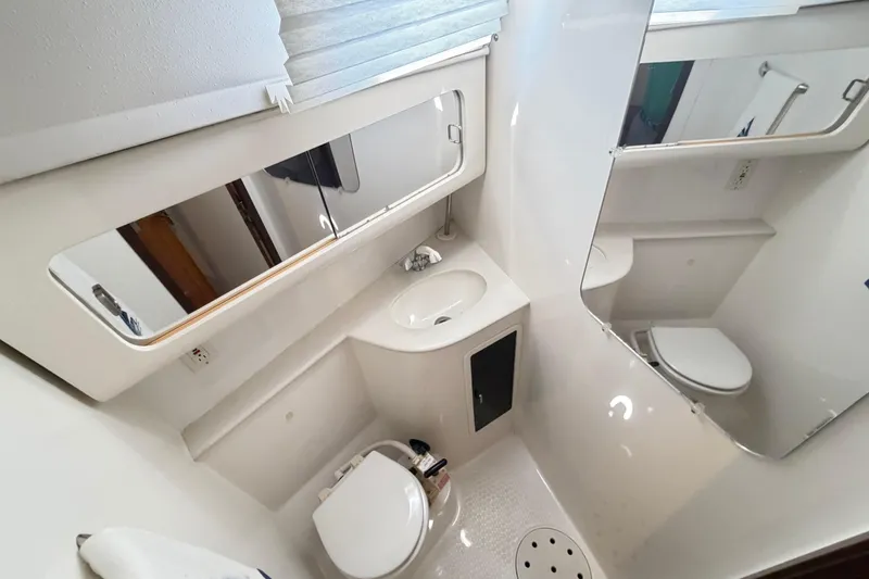 Slide: The Image of Compact bathroom in a 1995 Catalina 400 yacht, featuring a toilet, sink, and mirror. - 40