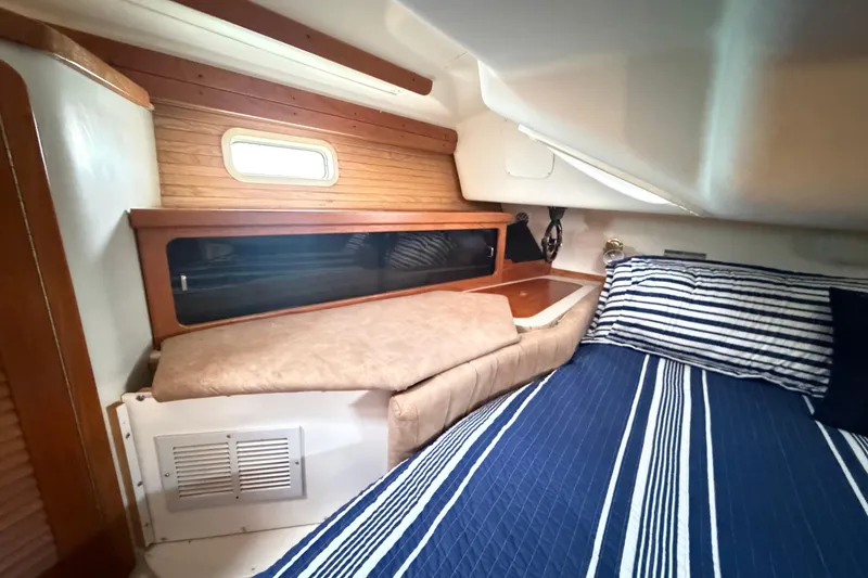 Slide: The Image of Cozy cabin interior of a 1995 Catalina 400 sailboat with striped bedding. - 34