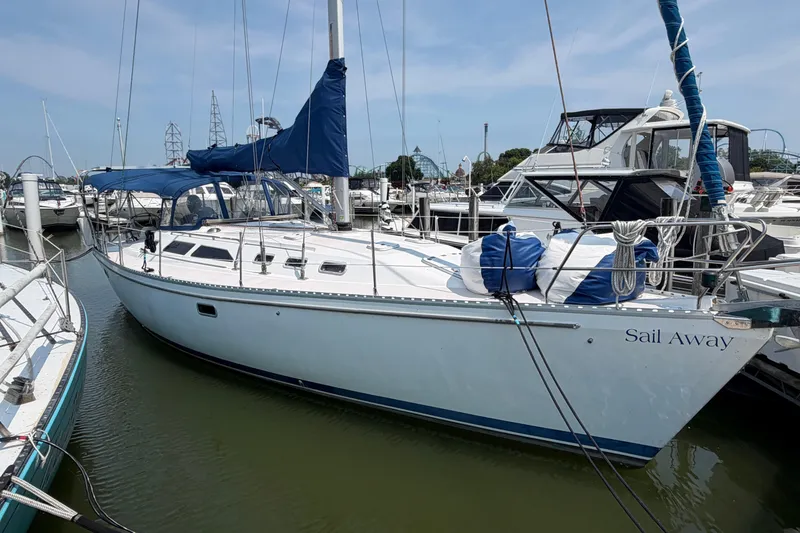 The Image of 1995 Catalina 400 sailboat docked in marina, named "Sail Away," with blue covers. - 0