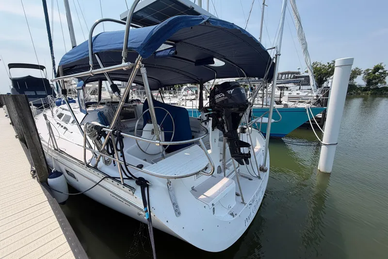 Slide: The Image of Catalina 400 sailboat, 1995 model, docked at marina with blue canopy and outboard motor. - 5