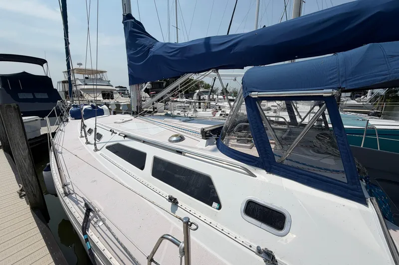 Slide: The Image of 1995 Catalina 400 sailboat docked at marina, featuring blue canvas covers and sleek design. - 3