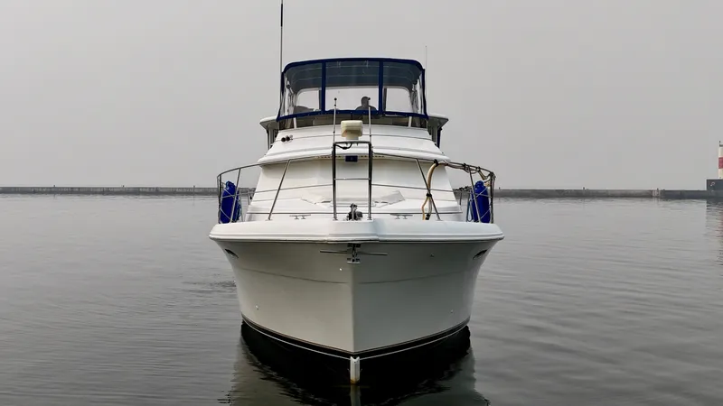 Slide: The Image of A 1997 Carver 445 Aft Cabin Motor Yacht sits calmly on the water, with a clear sky in the background. - 7