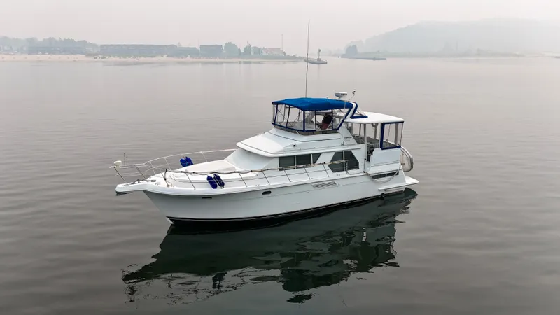 Slide: The Image of A white 1997 Carver 445 Aft Cabin Motor Yacht floats calmly on still water. - 1