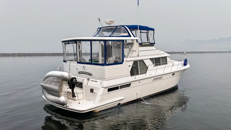 Slide: The Image of A white 1997 Carver 445 Aft Cabin Motor Yacht floats calmly on the water. - 12