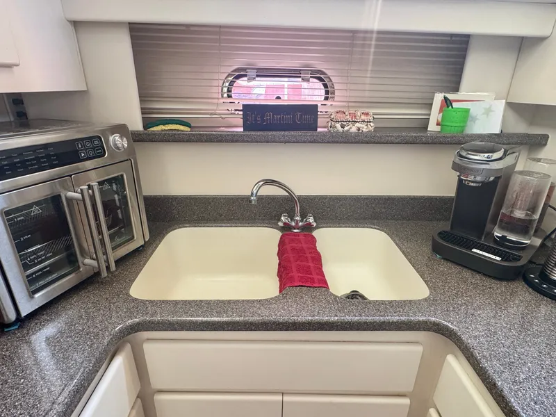 Slide: The Image of The 1997 Carver 445 Aft Cabin Motor Yacht's kitchen features a sink, microwave, and coffee maker. - 38