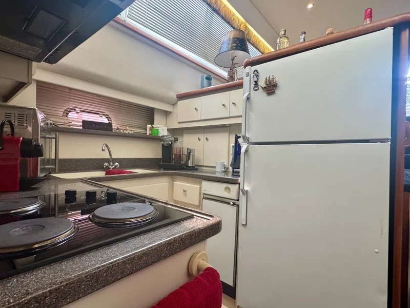 Slide: The Image of The galley of a 1997 Carver 445 Aft Cabin Motor Yacht with stove, sink, and refrigerator. - 37