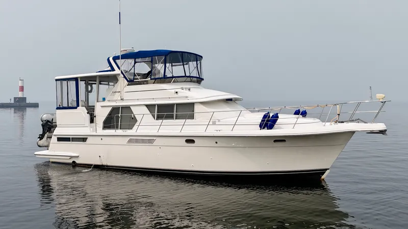 The Image of A white 1997 Carver 445 Aft Cabin Motor Yacht floats calmly on the water. - 0